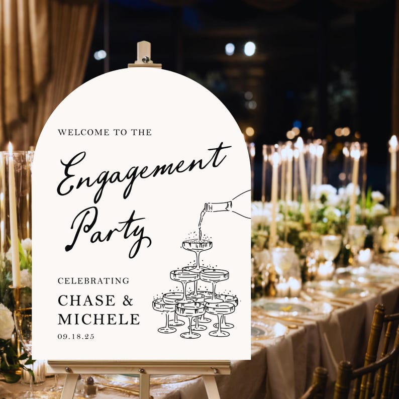 K&ouml;nnte beinhalten: Ein wei&szlig;es Schild mit schwarzem Text und einer Zeichnung von Champagnergl&auml;sern. Der Text lautet "Willkommen zur Verlobungsfeier Zur Feier von Chase & Michele 09.18.25".