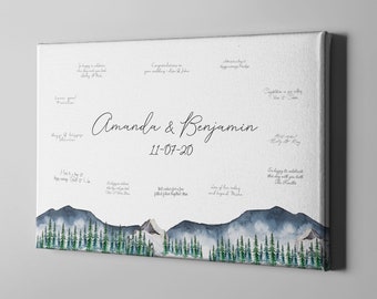 May include: A white canvas with a watercolour mountain landscape at the bottom. The canvas is a guest book for a wedding with the names Amanda & Benjamin and the date 11-07-20.