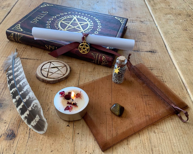 Peut inclure: Un kit de sortil&egrave;ges de sorci&egrave;re avec un livre intitul&eacute; "Spells", un parchemin, un pentagramme en bois, une petite bouteille d'herbes, une bougie, une plume, une pierre &oelig;il de tigre et une pochette brune.