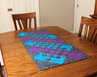 Camino de mesa ancho acolchado con estampado paisley en azul, verde azulado y morado.