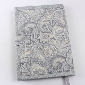 Pu&ograve; includere: Una copertina per libro con motivo paisley grigio e bianco con un bordo in tessuto grigio e un nastro grigio.