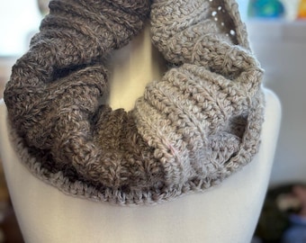 May include: A brown and beige crocheted infinity scarf with a textured pattern.
