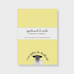 May include: A yellow notepad with the text "apartment 2 cards" and "NOTEPAD | 60 SHEETS" in white. Below is a sheep graphic with the text "i'd rather be knitting". Printed on recycled paper in the USA.