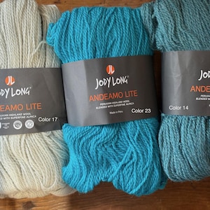 May include: Three skeins of Jody Long Andean Lite yarn in shades of off-white, turquoise, and teal. Each skein is labeled with the color number and the blend of Peruvian highland wool and superfine alpaca.