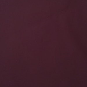 Peut inclure: Fond d'écran uni de couleur bordeaux avec une texture subtile. La couleur profonde et riche remplit le cadre, créant une toile de fond simple mais visuellement attrayante. La couleur est une nuance foncée de rouge avec une pointe de violet.