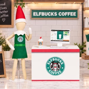 May include: A miniature elf doll wearing a green apron and red hat stands beside a white counter labeled Elfbucks Coffee. The counter features a computer monitor, a small coffee cup, and a logo with a siren graphic. A sign reads Santa Approves This Brew.