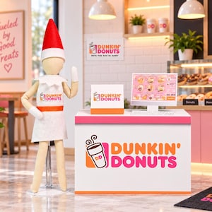 May include: A miniature elf figurine wearing a red hat and white apron stands beside a Dunkin' Donuts counter display. The setup includes a digital menu screen, a branded sign, and a white counter featuring the Dunkin' Donuts logo and coffee cup icon.