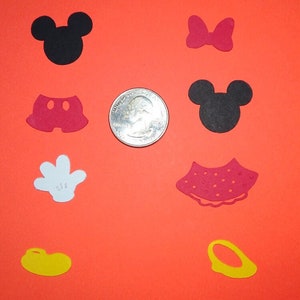 Puede incluir: Surtido de recortes de papel rojo, negro, blanco y amarillo de los personajes de Mickey Mouse y Minnie Mouse. Los recortes incluyen la cabeza de Mickey Mouse, la cabeza de Minnie Mouse, los pantalones cortos de Mickey Mouse, la falda de Minnie Mouse, el guante de Mickey Mouse, el lazo de Minnie Mouse y los zapatos de Mickey Mouse. Los recortes son aproximadamente del tama&ntilde;o de una moneda de 20 c&eacute;ntimos de euro.