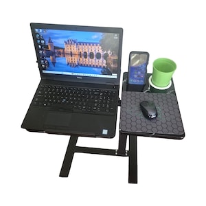 Pode incluir: Uma mesa para laptop preta com um laptop, um smartphone, um copo verde e um mouse. O laptop exibe uma imagem panorâmica. A mesa tem uma plataforma separada para o mouse e o copo.