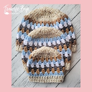 Op de afbeelding: Vier gehaakte mutsen in verschillende maten, op elkaar gestapeld. De hoeden hebben een granny square ontwerp met beige, bruin, blauw, wit en grijs. De tekst "Traverse Bays Crochet" staat bovenaan de afbeelding.