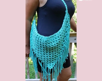 May include: A turquoise crochet shoulder bag with fringe. The bag has a triangular shape and a long strap. The bag is made of a woven, open-weave pattern. The words "Traverse Bay Crochet" are in the upper right corner.