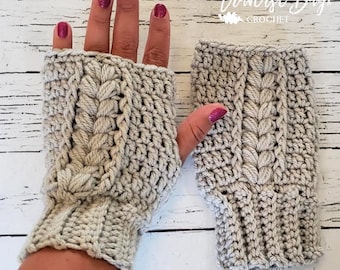 May include: A pair of light gray fingerless gloves with a cable knit design. The gloves are handmade with a textured, chunky yarn. The text "Traverse Bay Crochet" is visible in the upper right corner.