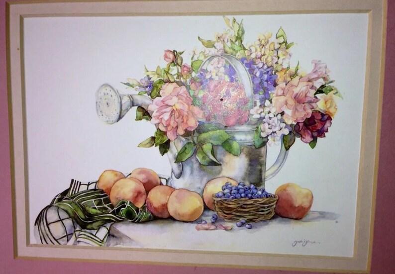 Puede incluir: Pintura a la acuarela de una regadera rebosante de flores rosas, moradas y amarillas. Melocotones y una peque&ntilde;a cesta de ar&aacute;ndanos se encuentran frente a la regadera, con un pa&ntilde;o a cuadros verdes y blancos.