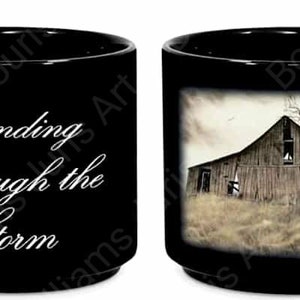 May include: Black ceramic coffee mug with a white image of a weathered barn and a bare tree. The text "Standing Through the Storm" is printed on the other side of the mug.