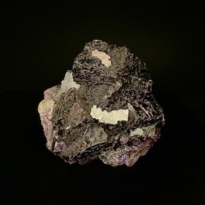 May include: A large, dark purple fluorite crystal with white veins. The crystal has a rough, textured surface and is irregularly shaped.