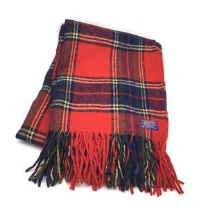 May include: Red and black plaid wool throw blanket with fringe. The blanket has a label that says "Pendleton".