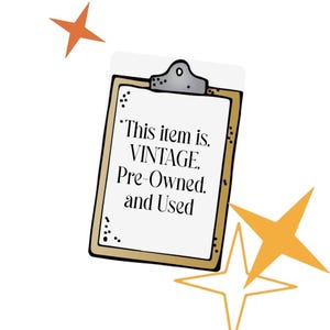 May include: A clipboard with a gold border and the text "This item is VINTAGE, Pre-Owned, and Used" in black. The clipboard has a silver clip at the top and is decorated with orange star shapes.