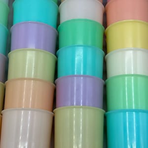 May include: A stack of pastel colored plastic cups. The cups are arranged in a rainbow pattern, starting with light blue at the top and ending with light blue at the bottom. The cups are all the same size and shape.