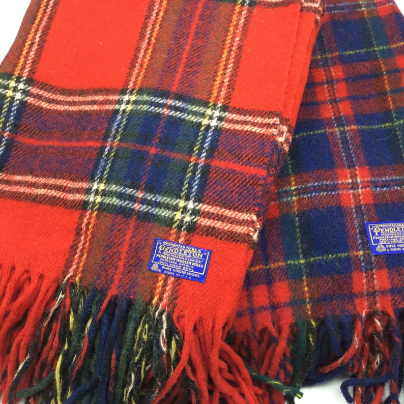 May include: Two red and blue plaid Pendleton wool blankets with fringe. The blankets have a label that reads "Woven to be a Pendleton."