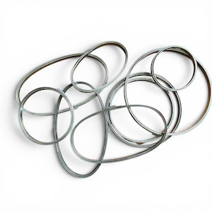 May include: A collection of multiple silver-toned metal rings and oval-shaped hoops with a smooth, reflective finish. The various sizes are arranged in an overlapping, interconnected cluster, showcasing thin, rounded bands of consistent thickness.