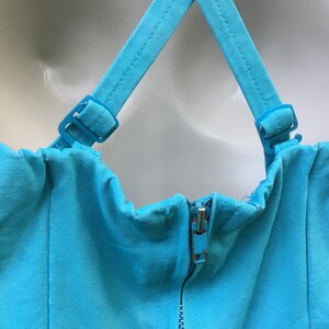 May include: A turquoise blue strapless dress with adjustable straps and a zipper closure in the back.