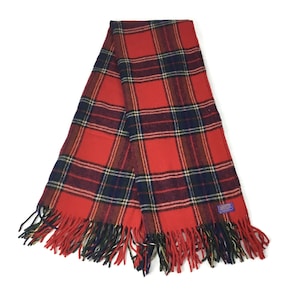 May include: Red and black plaid throw blanket with fringe. The blanket is folded in half and has a blue label with the text "Aberdeen" on it.