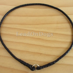 Pu&ograve; includere: Un collare per cani in pelle nera con un design intrecciato e un anello argentato.