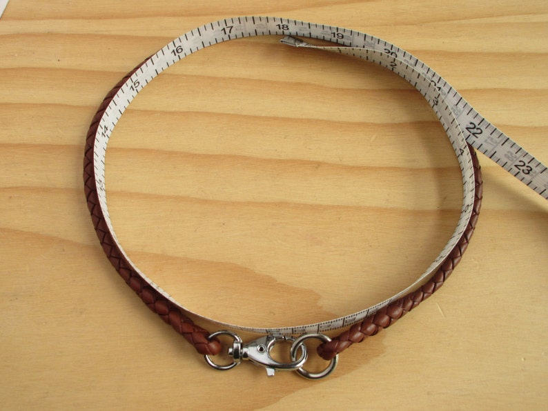 Puede incluir: Un cord&oacute;n de cuero marr&oacute;n con un cierre plateado, medido con una cinta m&eacute;trica de 17 pulgadas de largo.