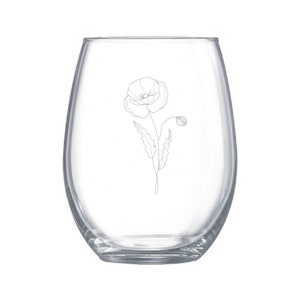 May include: A clear glass stemless wine glass with a delicate line drawing of a poppy flower etched on the side.