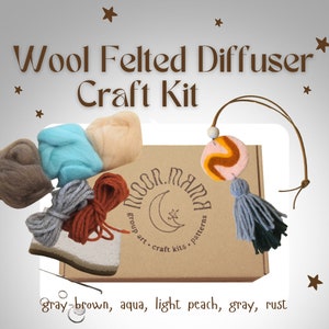 May include: A wool felted diffuser craft kit. The kit contains brown, aqua, light peach, grey, and rust-coloured wool, a decorative felted piece, and a tassel. The box is labelled "Moon Mama".