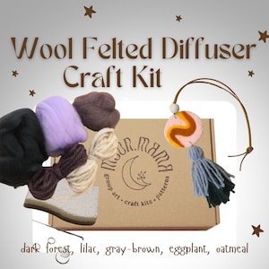 Könnte beinhalten: Ein Bastelset zum Herstellen eines Wollfilz-Diffusors. Das Set enthält Wolle in fünf Farben: Dunkelwald, Flieder, Graubraun, Aubergine und Haferflocken. Das Set enthält außerdem einen Filzdiffusor, einen Quasten und eine Nadel. Das Set ist in einer braunen Box verpackt, auf der "Moon Mama" steht.