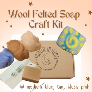 Puede incluir: Kit de manualidades de fieltro de lana con una caja marrón, una pastilla de jabón, una aguja, una almohadilla de fieltro y cuatro ovillos de lana en azul, marrón y rosa claro. La caja tiene las palabras "Moon Mama" y "group art craft kits patterns" impresas. El kit es para hacer jabón de fieltro.