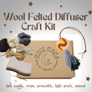 May include: A craft kit for making a wool felted diffuser. The kit includes wool felt in various colours, a wooden bead, a felt circle with a swirl design, a piece of string, and a small sponge. The box is labelled "Moon Mama Group Art Craft Kits Patterns".