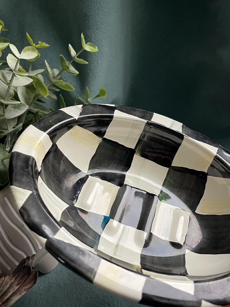May include: Oval ceramic soap dish featuring a black and white chequered design. The dish has a raised rim and a glossy finish. A classic, bold design for any bathroom, with a nod to traditional style.