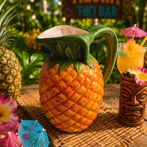 May include: A ceramic pineapple-shaped pitcher with a green handle and leaves. The pitcher sits on a woven mat, with a tiki mug and a cocktail with a parasol in the background. The sign in the background says "Aloha Tiki Bar".