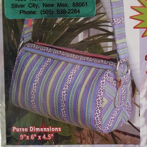 May include: A colorful fabric bag with a zippered closure and a strap. The bag is 9 inches by 6 inches by 4.5 inches. The bag is called "the Cirque Sac" and is part of the "Bags with Panache" collection. The text on the image says "Sleek and Stylish" and "Fashionably Functional".