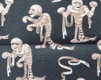 100% cotton Quilting fabric.  PRICED by the 1/2 yard and cut on order.  Spooky Halloween mummy's mummy wrapping print fun. Brown & black