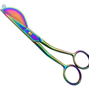 May include: Rainbow iridescent stainless steel shears with a curved blade and a rounded handle. The shears have a gold screw in the center.