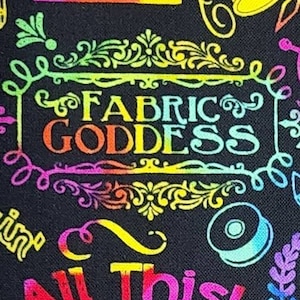 May include: Black fabric with a colorful sewing machine, thimble, and the words "Fabric Goddess." The design includes the phrases "All This! AND I Sew Too!" in vibrant hues. A fun, creative theme for sewing enthusiasts.
