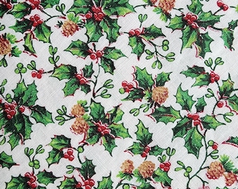 May include: A white fabric with a repeating pattern of green holly leaves, red berries, and brown pinecones.