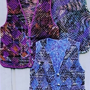 May include: Three sleeveless vests with a V-neck and a button closure. The vests are made of a crinkled fabric with a colorful abstract pattern. The vests are in shades of purple, blue, and black.