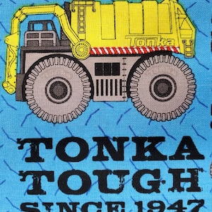 May include: A yellow Tonka toy dump truck with a gray cab and wheels on a blue background with the text "Tonka Tough Since 1947".
