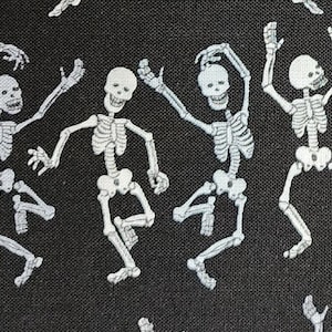 100% cotton Quilting fabric.  PRICED by the 1/2 yard and cut on order.  Spooky white directional dancing  skeletons on black.  Too cute