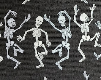 100% cotton Quilting fabric.  PRICED by the 1/2 yard and cut on order.  Spooky white directional dancing  skeletons on black.  Too cute