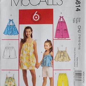 May include: McCall's M5614 sewing pattern featuring six different looks for girls. The pattern includes options for tops, dresses, and pants. The cover shows illustrations of the finished garments, including a blue polka dot dress and yellow pants.