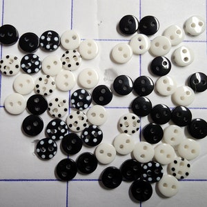 May include: A collection of small, round buttons in black and white. Some buttons are solid black or white, while others feature a polka dot pattern. Each button has two holes for sewing.