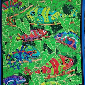 May include: A colorful fabric featuring a repeating pattern of green leaves and brightly colored chameleons. The chameleons are in various poses, some with their tongues extended, and are decorated with spots, stripes, and swirls.