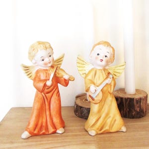 Angels in ceramic one with Mandolin and another with a violin both pretty, colorful and a collectable shelf sitter for Holidays and beyond