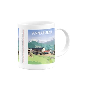 May include: White ceramic mug with a colorful illustration of a mountain range and a village. The text "ANNAPURNA" is printed in red on the mug. The text "MASSIF IN THE HIMALAYAS IN NORTH-CENTRAL NEPAL" and "Forming part of the Annapuma Conservation Area" is printed in red on the side of the mug.