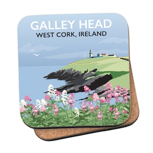 Puede incluir: Un posavasos cuadrado de corcho con una ilustración colorida de un faro en una costa rocosa con flores en primer plano. El texto "GALLEY HEAD WEST CORK, IRELAND" está impreso en el posavasos.
